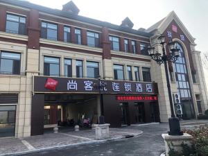 een gebouw met een bord aan de voorkant bij Thank Inn Chain Hotel Liaocheng Yanggu County Fucheng in Liaocheng