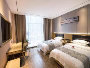 um quarto de hotel com duas camas e uma televisão de ecrã plano em Thank Inn Chain Hotel Ganzhou Zhanggong District Wanxiang City em Ganzhou