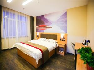 a bedroom with a bed and a painting on the wall at Thank Inn Chain Hotel Panjin Shuangtaizi District Railway Station in Panjin