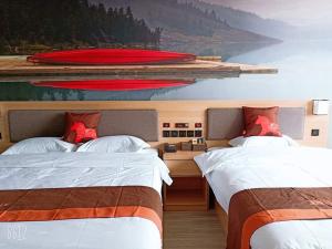 um quarto com duas camas e uma pintura de um barco em JUN Hotels Hebei Hengshui Renmin Road 13 Middle School em Hengshui