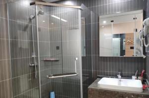 a bathroom with a shower with a sink and a mirror at Thank Inn Chain Hotel Shandong Qingdao Huangdao West Coast Bus Station in Qingdao