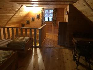 pokój z łóżkiem i schodami w kabinie w obiekcie Mazurska Chatka w mieście Zyzdrojowy Piecek