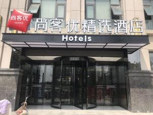 una señal de hotel en la parte delantera de un edificio en Thank Inn Plus Hotel Shijiazhuang Gaocheng District Century Avenue, en Shijiazhuang