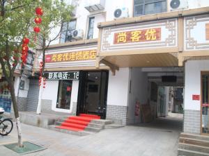 a building with red steps in front of a store at Thank Inn Chain Hotel Jiangxi Ganzhou Quannan County Shoumei Road in Quannan