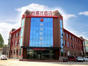 een groot rood gebouw met Chinees schrift erop bij Thank Inn Chain Hotel Shandong Linyi Lanshan District Liguan Town in Linyi