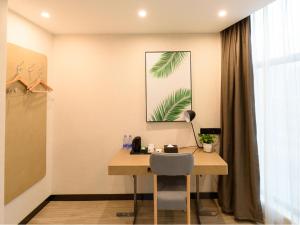 a desk with a chair next to a window at Up And In Sichuan Mianyang Sena Sunshine High-speed Railway Station in Mianyang