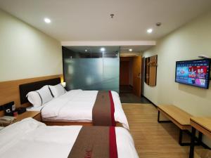 a hotel room with two beds and a flat screen tv at Thank Inn Plus Hotel Shijiazhuang Gaocheng District Century Avenue in Shijiazhuang