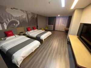 a hotel room with two beds and a flat screen tv at Thank Inn Chain Hotel Hebei Handan Ci County Xinshiji in Handan
