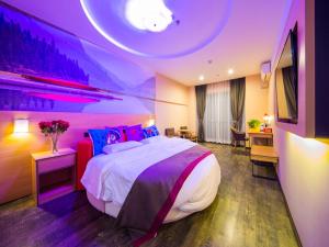 Thank Inn Chain Hotel Guizhou Zunyi Xinpu New District Meidi City في زونيي: غرفة نوم بسرير كبير مع اضاءة ارجوانية