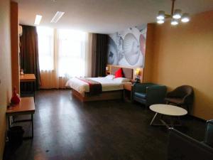Habitación de hotel con cama, mesa y sillas en Thank Inn Chain Hotel Xinxiang Yuanyang Jianshe Road Hualong Shangjun, en Xinxiang