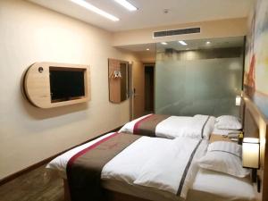 a hotel room with two beds and a tv at Thank Inn Chain Hotel Hebei Baoding Wangdu County Bus Station in Baoding