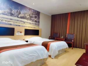 a hotel room with two beds and a tv at JUN Hotels Hunan Zhuzhou Lusong District Central Plaza in Zhuzhou