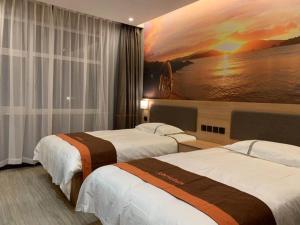 a hotel room with two beds and a painting on the wall at JUN Hotels Hebei Baoding Rongcheng Banzheng North Street Store in Baoding