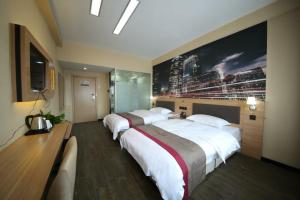 a hotel room with two beds and a large painting on the wall at Thank Inn Chain Hotel Shandong Linyi Lanshan District Liguan Town in Linyi