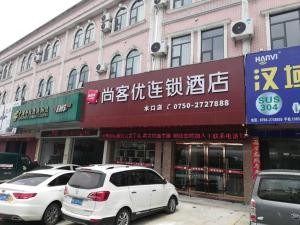 two white cars parked in front of a building at Thank Inn Chain Hotel Jiangmen Kaiping Shuikou Passenger Transport Station in Jiangmen