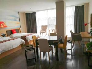 六安的住宿－尚客优酒店安徽六安舒城县远大港汇店，酒店客房带两张床和一张桌子以及椅子。