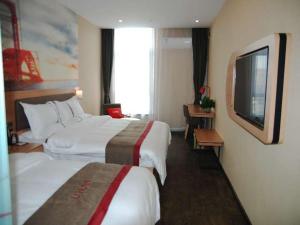 a hotel room with two beds and a flat screen tv at Thank Inn Chain Hotel Tianjing Jingnan District Balitai Town Industrial Park in Tianjin