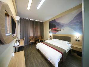 a hotel room with a large bed and a table at Thank Inn Chain Hotel Shandong Dezhou Lingcheng District Lingzhou Road Ginza in Dezhou