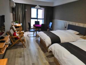 a hotel room with two beds and a table and chairs at Up and In Hubei Xiaogan Yunmeng County Huguang Road 