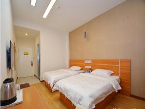 1 dormitorio con 2 camas y TV. en JUN Hotels Henan Luoyang Xigong District Central Bus Station, en Luoyang