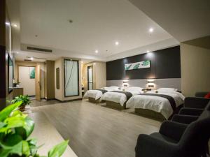 a hotel room with four beds and a tv at Up and In Shanxi Taiyuan Zonggai Shifanqu in Taiyuan