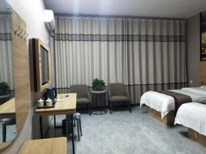 um quarto de hotel com uma cama, uma mesa e cadeiras em Thank Inn Chain Hotel Shandong Linyi Linshu County Cangshan South Road em Linyi