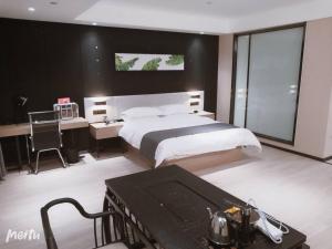 1 dormitorio con cama grande, escritorio y sidra de mesa en Thank Inn Chain Hotel Heze Mudan District China Peony Garden, en Heze