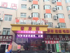 ein Gebäude mit Schildern auf der Vorderseite in der Unterkunft JUN Hotels Henan Luoyang Xigong District Central Bus Station in Luoyang