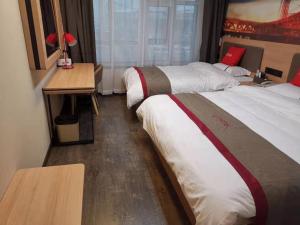 a hotel room with two beds and a table with a desk at Thank Inn Chain Hotel Shanxi Changzhi Huguan County Bus Station Store in Changzhi