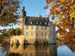 a castle in the middle of a body of water at Sehr schöne Ferienwohnung im historischen Borken-Gemen in Borken