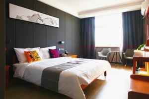 a bedroom with a large bed with colorful pillows at JUN Hotels Hebei Hengshui Gucheng County Yingrui Plaza in Hengshui
