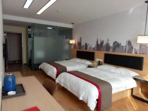 Un dormitorio con 2 camas y una pared con una foto. en Thank Inn Chain Hotel Chizhou Zhanqian District Railway Station, en Chizhou