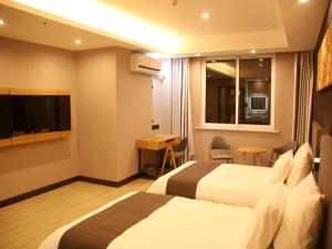 a hotel room with two beds and a flat screen tv at Up And In Jiangsu Yancheng Tinghu District Yancheng Bridge Store in Yancheng