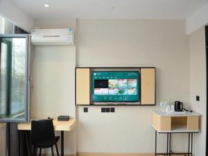 a room with a flat screen tv on a wall at Up And In Rizhao Wulian County Wulian Square in Rizhao
