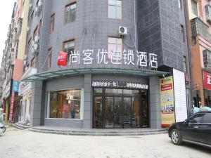 Un bâtiment avec des écrits asiatiques à l'avant dans l'établissement Thank Inn Chain Hotel Xinyang Gushi County Hongsu Avenue, 
