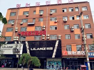 un gran edificio marrón con un cartel. en JUN Hotels Hebei Handan Weixian Bus Station Store, en Handan