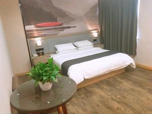a bedroom with a large bed and a table at Thank Inn Plus Hotel Jiangsu Suzhou Taicang Liuhe Town Tinghai Road in Taicang