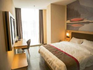 ein Hotelzimmer mit einem Bett, einem Schreibtisch und einem Fenster in der Unterkunft Thank Inn Chain Hotel Guizhou Guiyang Guanshanhu District Century City Store in Guiyang