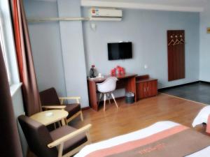 Habitación con 1 dormitorio con escritorio y TV. en JUN Hotels Hebei Handan Weixian Bus Station Store, en Handan