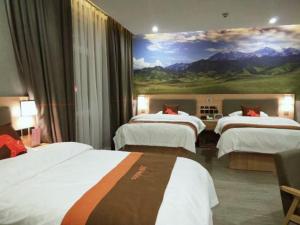 a hotel room with three beds and a painting on the wall at JUN Hotels Gansu Zhangye Linze County Bus Station in Zhangye