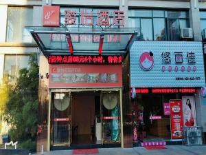 un restaurante con un cartel en la parte delantera de un edificio en JUN Hotels Anhui Huangshan Tunxi District Huangshan Old Street, en Huangshan