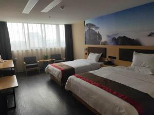 a hotel room with two beds and a table and chairs at Thank Inn Chain Hotel Anhui Bozhou Qiaocheng District Jian'an Road Wanfu Store in Bozhou