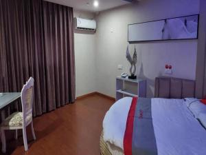 ein Hotelzimmer mit einem Bett, einem Schreibtisch und einem Fenster in der Unterkunft JUN Hotels Shanghai Chongming Xuegong Road Meizhou Road in Shanghai
