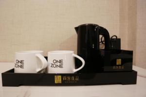 a tray with two coffee mugs and a black appliance at Up and In Kashgar Xiyu Avenue Food Street in Kashgar
