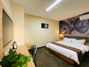 una habitación de hotel con una cama grande y una mesa en Thank Inn Chain Hotel Jiangsu Suzhou High-tech Zone Majian Xintiandi, en Suzhou