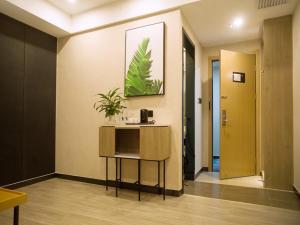 una habitación con una mesa con una planta en la pared en Up And In Baotou Qingshan District Central International, en Baotou