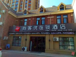 un edificio con un cartel en la parte delantera en Thank Inn Chain Hotel Xinxiang Yuanyang Jianshe Road Hualong Shangjun, en Xinxiang