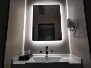 a bathroom with a sink and a mirror at Up And In Ganzhou Zhanggong District Baoneng City in Ganzhou