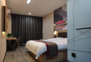 a hotel room with a bed and a desk in it at Thank Inn Chain Hotel Shandong Qingdao Huangdao West Coast Bus Station in Qingdao