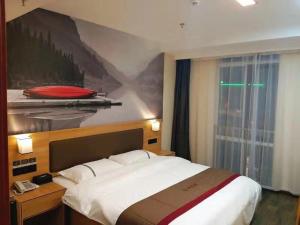 ChangshuにあるThank Inn Chain Hotel Jiangsu Suzhou Changshu Haiyu Townのベッドルーム1室(ベッド1台付)が備わります。壁には絵画が飾られています。